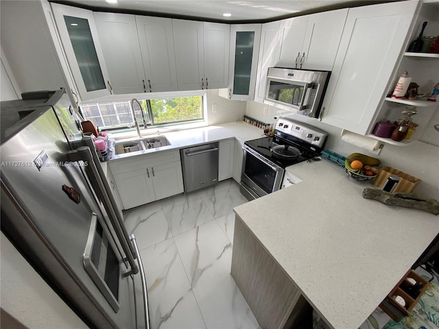 kitchen featuring light stone counters, sink, stainless steel appliances, and white cabinets