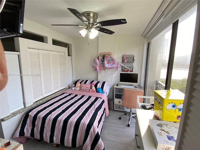 bedroom with hardwood / wood-style floors, a closet, and ceiling fan