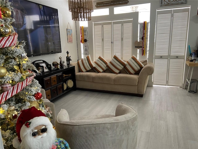 living room with light hardwood / wood-style floors and a chandelier