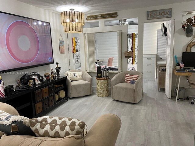 living room with ceiling fan and light hardwood / wood-style flooring