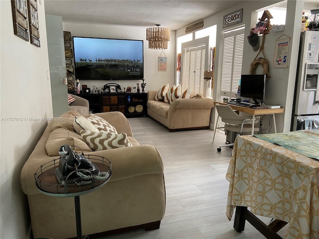 living room featuring a textured ceiling and light wood-type flooring