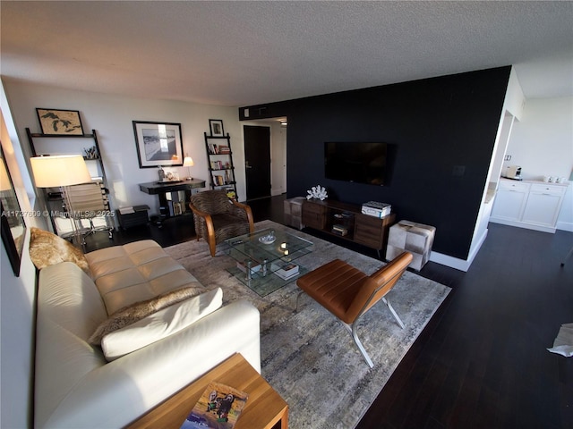 living room with a textured ceiling, baseboards, and wood finished floors