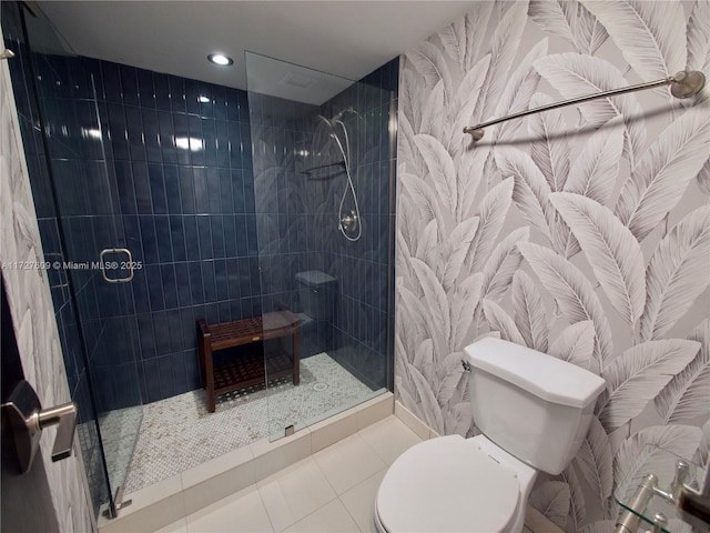 bathroom with tile patterned floors, toilet, and a shower with shower door