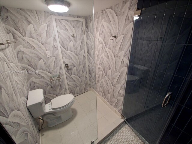 bathroom with a tile shower, tile patterned floors, and toilet