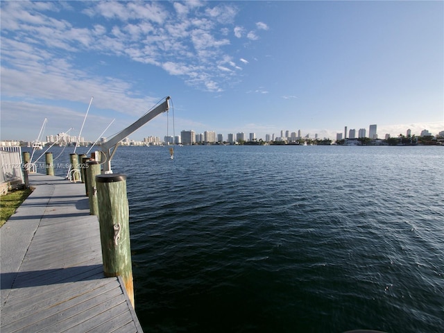 view of dock featuring a view of city, a water view, and boat lift