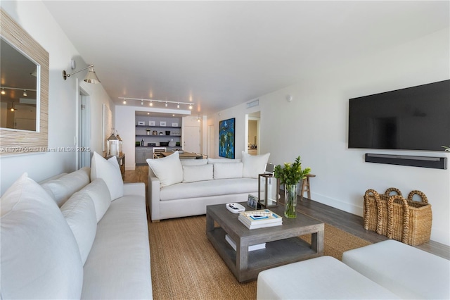 living room featuring built in shelves and hardwood / wood-style floors