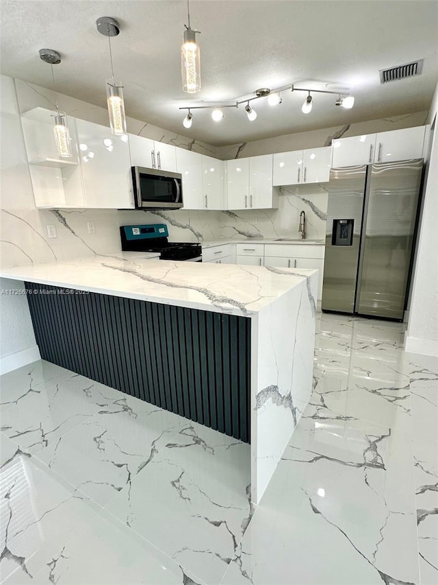 kitchen with decorative light fixtures, kitchen peninsula, sink, white cabinetry, and appliances with stainless steel finishes