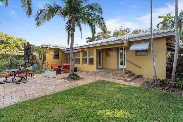 rear view of property with a yard and a patio area