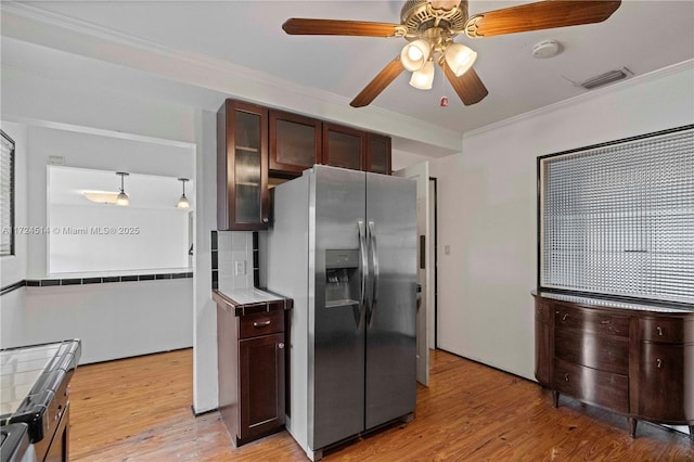 kitchen featuring tile countertops, decorative light fixtures, ceiling fan, stainless steel fridge with ice dispenser, and crown molding