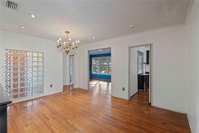 interior space featuring a notable chandelier, hardwood / wood-style flooring, and ornamental molding