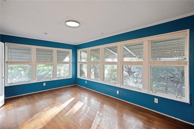 interior space with crown molding, plenty of natural light, and hardwood / wood-style flooring