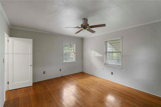 unfurnished bedroom with multiple windows, ornamental molding, hardwood / wood-style floors, and ceiling fan