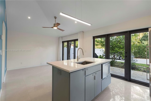 kitchen with gray cabinets, sink, a kitchen island with sink, ceiling fan, and french doors