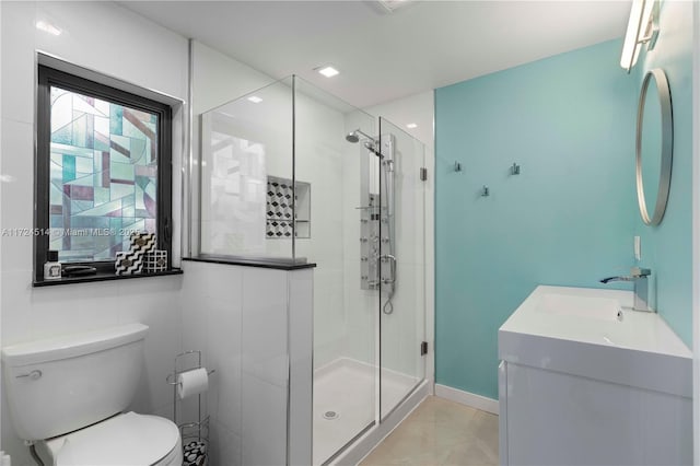 bathroom featuring vanity, a shower with shower door, tile patterned floors, and toilet