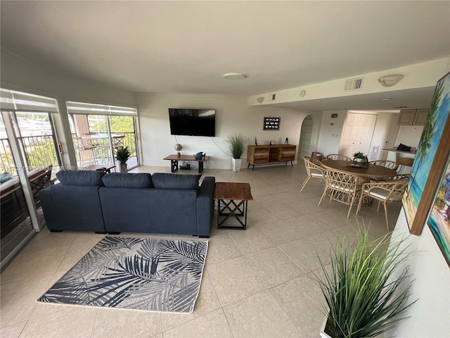 living room featuring visible vents, arched walkways, and light tile patterned flooring