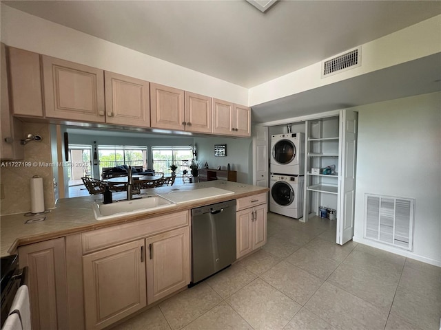 kitchen with stainless steel dishwasher, stacked washer / drying machine, visible vents, and a sink