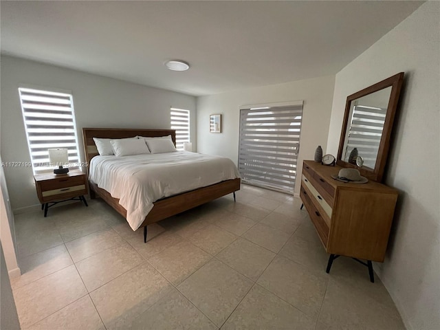 bedroom featuring multiple windows and light tile patterned flooring