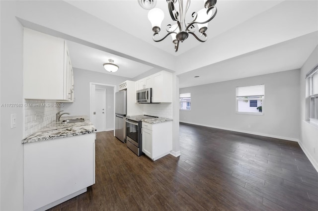 kitchen with stainless steel appliances, dark hardwood / wood-style flooring, white cabinetry, and tasteful backsplash