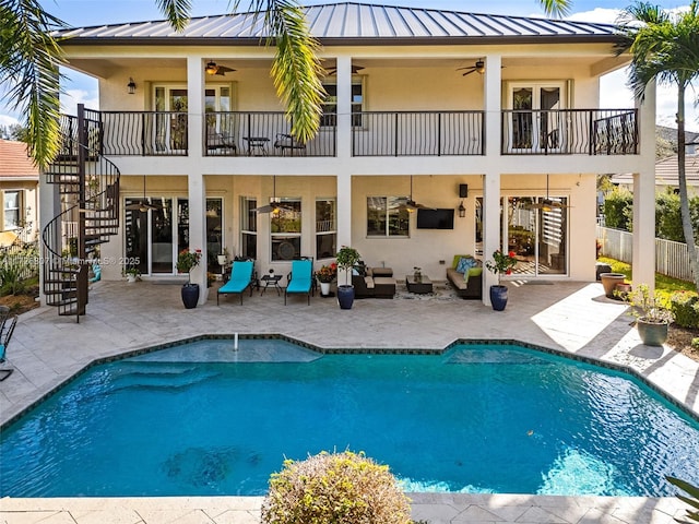 rear view of property with ceiling fan, stairway, a standing seam roof, a patio area, and stucco siding