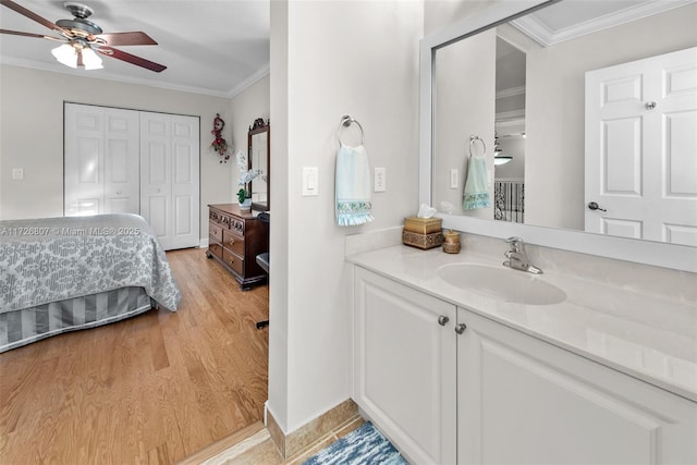 bathroom featuring ensuite bath, ornamental molding, a closet, and wood finished floors