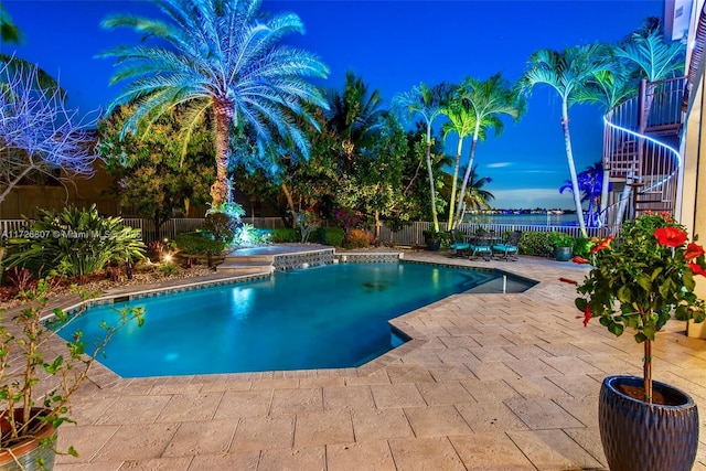 pool at dusk with a patio, stairway, a fenced backyard, and a fenced in pool