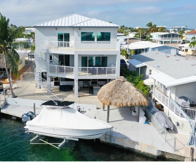 back of property with a water view and a gazebo