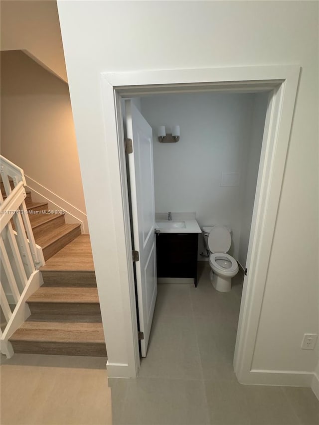 bathroom featuring toilet, vanity, and tile patterned flooring