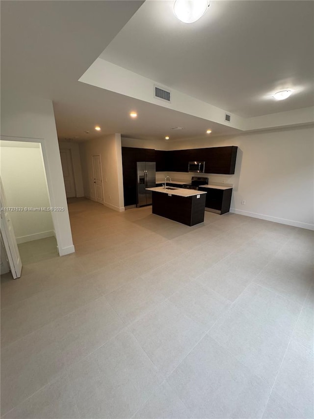 kitchen featuring sink, appliances with stainless steel finishes, and a kitchen island with sink