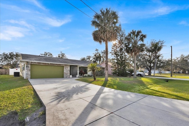 ranch-style house with a front yard, central air condition unit, and a garage