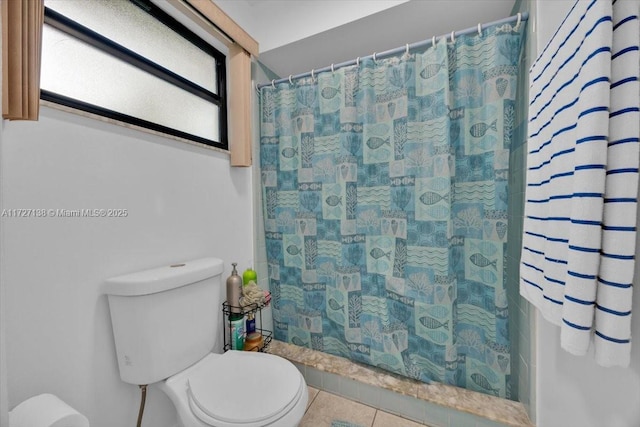 bathroom with a shower with curtain, toilet, and tile patterned flooring