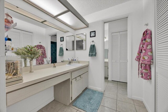 3270 Deer Lick, Kissimmee, FL 34746 - bathroom featuring a textured ceiling, vanity, and tile patterned flooring