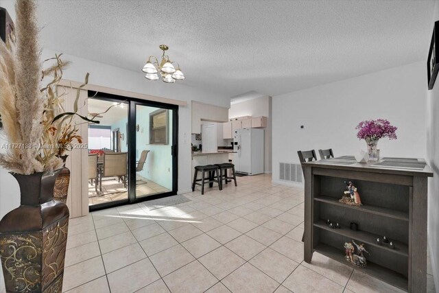 3270 Deer Lick, Kissimmee, FL 34746 - tiled dining area featuring a textured ceiling and a notable chandelier