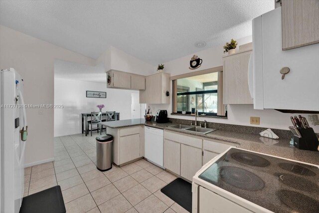 3270 Deer Lick, Kissimmee, FL 34746 - kitchen featuring white appliances, light tile patterned flooring, vaulted ceiling, sink, and kitchen peninsula