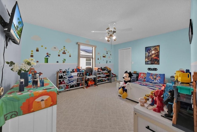 carpeted bedroom with a textured ceiling, a closet, and ceiling fan