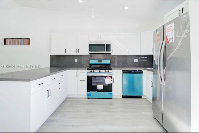 kitchen with kitchen peninsula, stainless steel appliances, and white cabinets