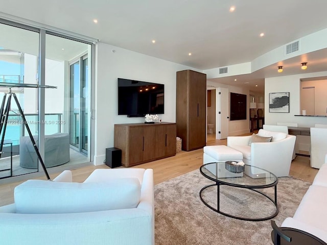 living room with light hardwood / wood-style flooring and a wall of windows