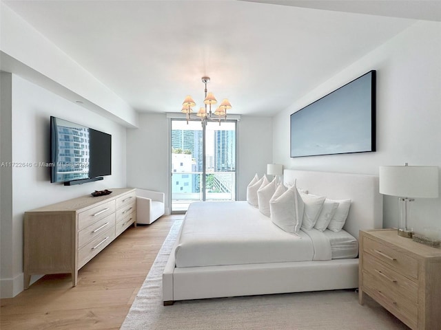 bedroom with a notable chandelier, access to exterior, and light wood-type flooring