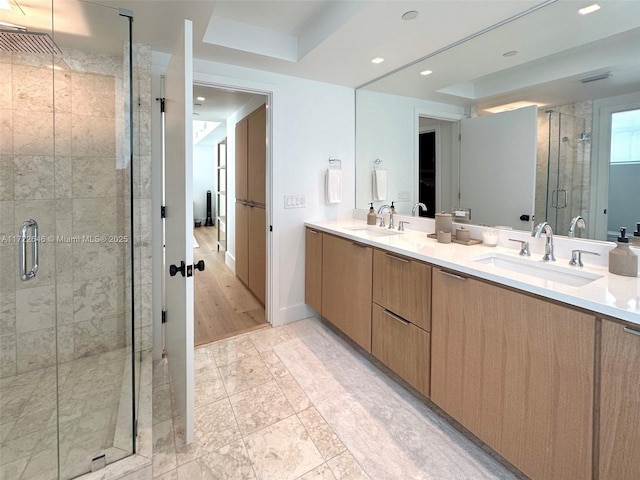 bathroom with a shower with door and vanity