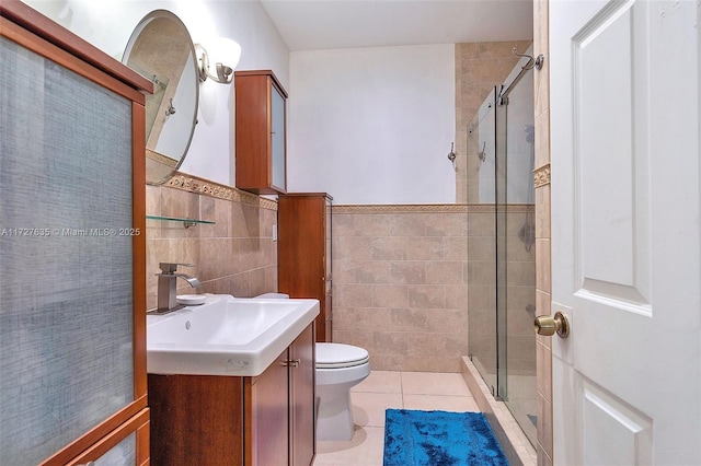 full bath with tile patterned flooring, a shower stall, vanity, and tile walls