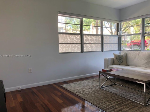 living room featuring a healthy amount of sunlight and dark hardwood / wood-style floors