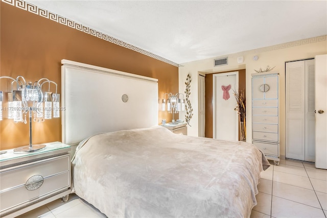 bedroom with light tile patterned floors and a closet