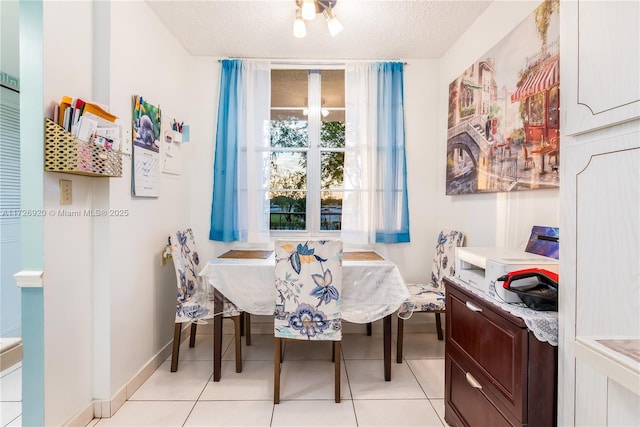 dining room with light tile patterned flooring, a textured ceiling, and breakfast area