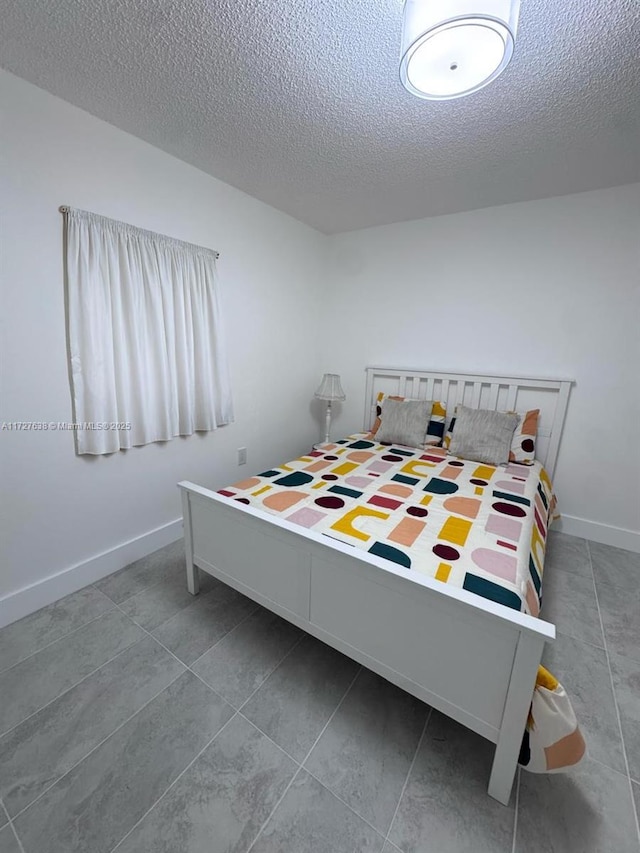 tiled bedroom featuring a textured ceiling