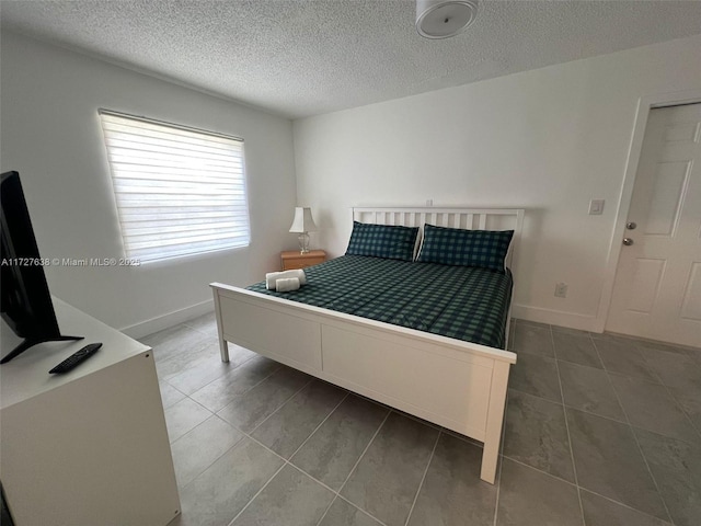 tiled bedroom featuring a textured ceiling