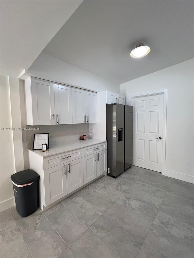 kitchen with white cabinets, tasteful backsplash, and stainless steel fridge