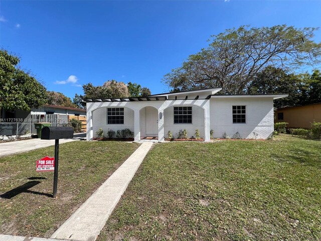 rear view of property with central AC unit and a yard