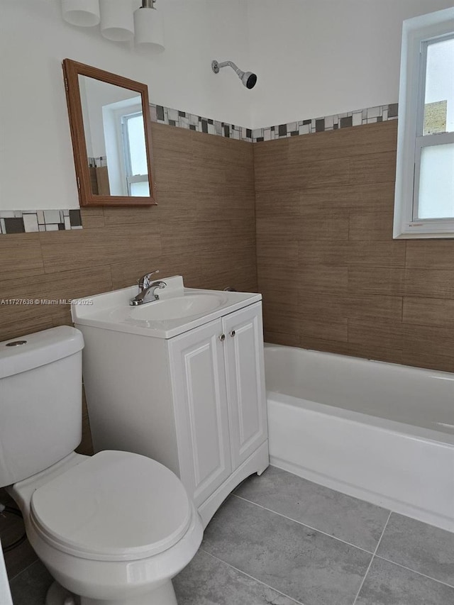 bathroom with toilet, vanity, tile walls, and tile patterned floors