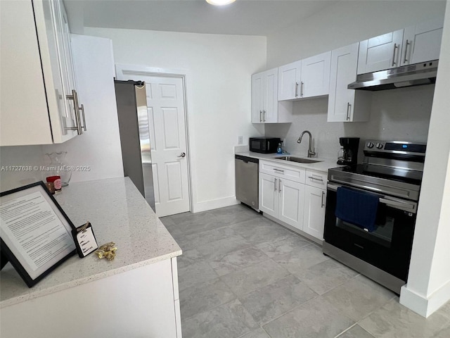 kitchen featuring light stone counters, appliances with stainless steel finishes, sink, and white cabinets