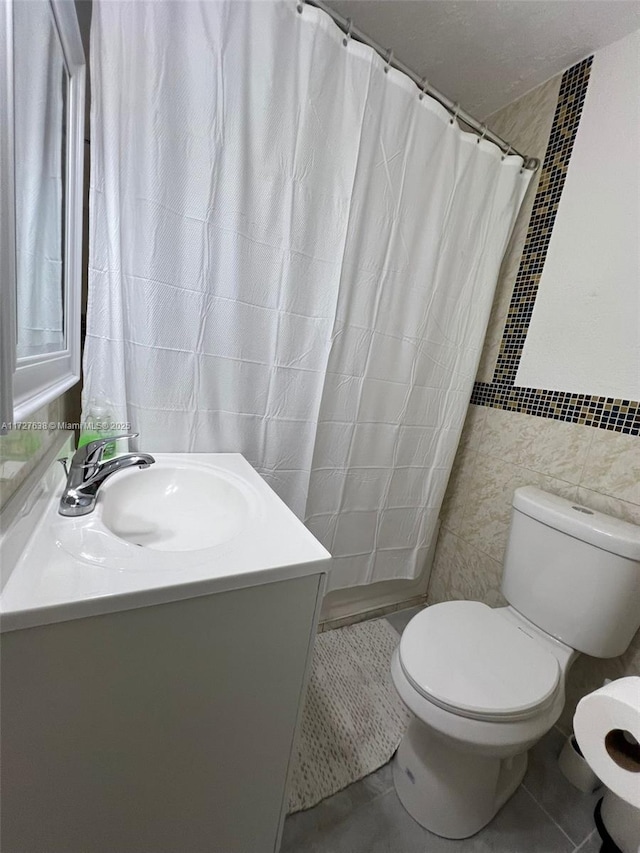 bathroom featuring tile walls, tile patterned flooring, a shower with curtain, and toilet