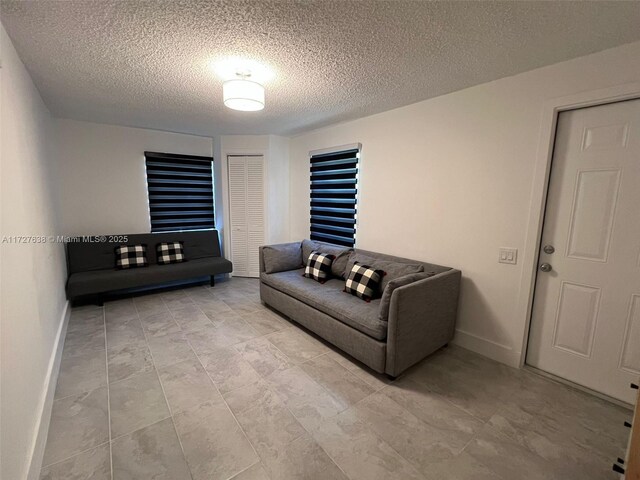 bedroom with light tile patterned flooring and a textured ceiling